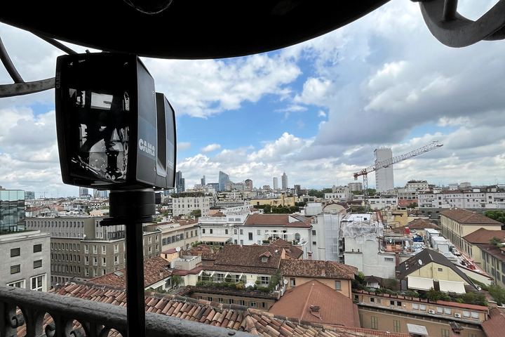 Laser scanner sul ballatoio di un campanile, sopra i tetti